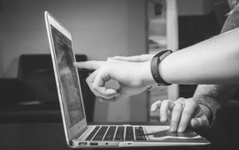 Someone showing another person something on a computer screen