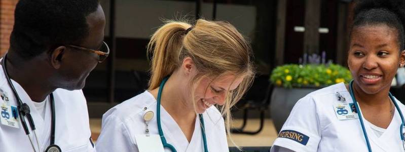 Nursing students conversing on bench