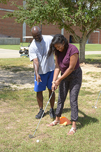 An individual student receiving golfing instruction