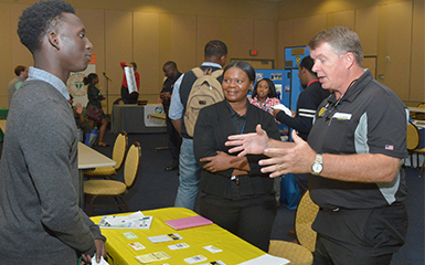 ASU student speaks with Waffle House representative at a career fair.