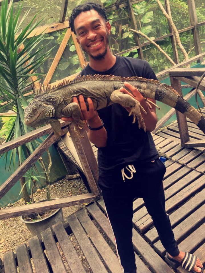 Student holding a large lizard.